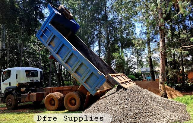 Dump truck unloading gravel at a site